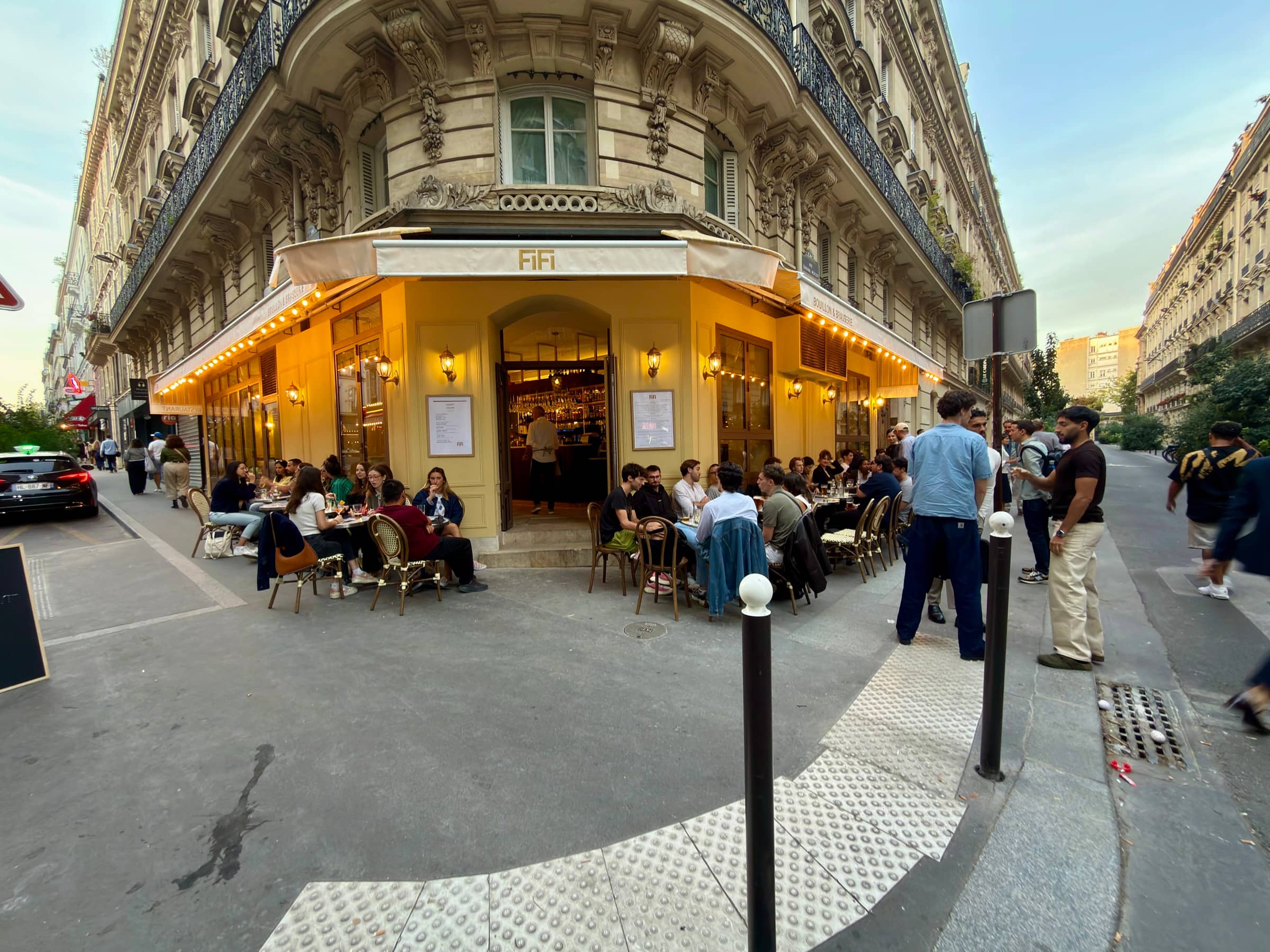La devanture de FiFi au crépuscule, 56B rue de Clichy, sa terrasse et son auvent éclairé